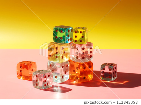 Close-up of colorful dice arranged over pink background with shadows 112845358