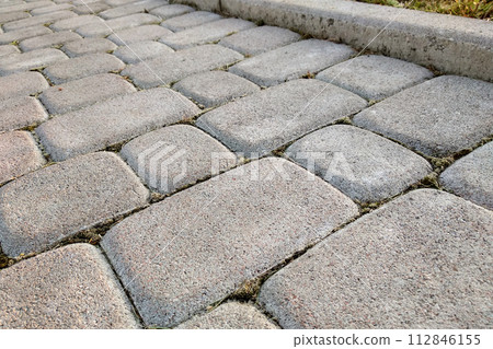 Close-up of slab stone paved path way at park or backyard. Walkway footpath road at house yard garden. Close-up of slab stone paved path way at park or backyard. Walkway footpath road at house yard garden. 112846155