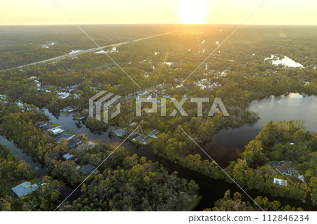 Consequences of natural disaster. Heavy flood with high water surrounding residential houses after hurricane rainfall in Florida residential area 112846234