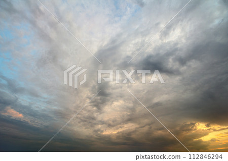 Sunset sky covered with orange puffy clouds in the evening. 112846294
