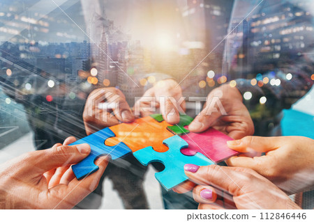 Businessmen working together to build a puzzle as teamwork, partnership and integration concept Businessmen working together to build a puzzle as teamwork, partnership and integration concept 112846446