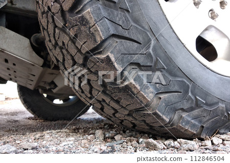 All terrain car tire on a wheel. 112846504