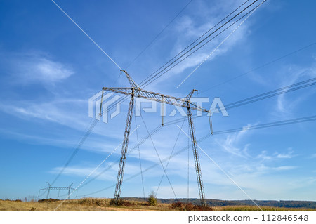 High voltage tower with electric power lines transfening electrical energy through cable wires High voltage tower with electric power lines transfening electrical energy through cable wires 112846548