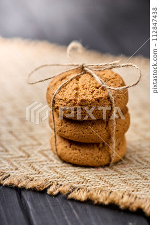 Oatmeal cookies tied with a rope on a wooden table. The concept of food for breakfast 112847438