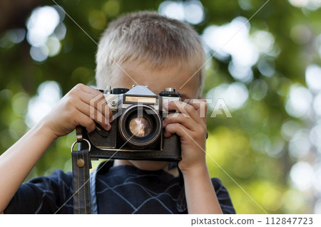 Cute little happy boy with vintage photo camera outdoors 112847723