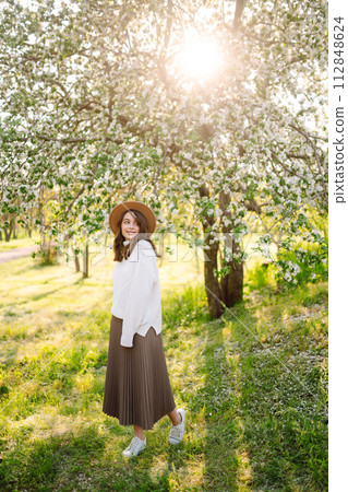 Beautiful young woman near blooming spring tree. Youth, love, fashion, romantic, lifestyle concept. Beautiful young woman near blooming spring tree. Youth, love, fashion, romantic, lifestyle concept. 112848624