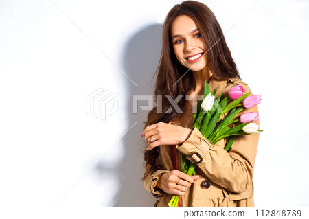 Fashion photo of beautiful woman with tulips in her hand. March 8. beautiful girl in stylish clothes 112848789