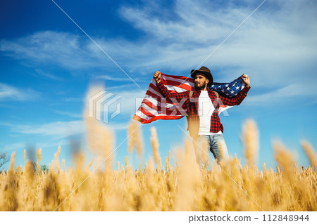 4th of July. American Flag.Patriotic holiday. Traveler with the flag of America. Beautiful sunset light. American style. 112848944