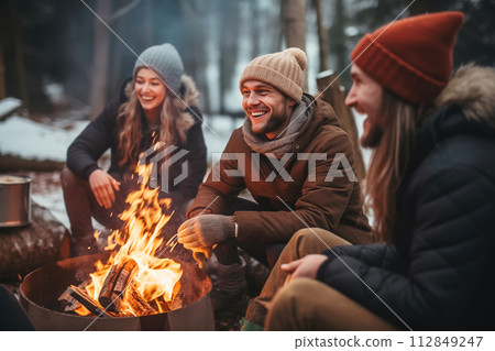 AI-generated content. Happy friends having fun and relaxing around fire. Winter party outside 112849247