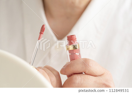 Woman's hand holding lip gloss Woman's hand holding lip gloss 112849531