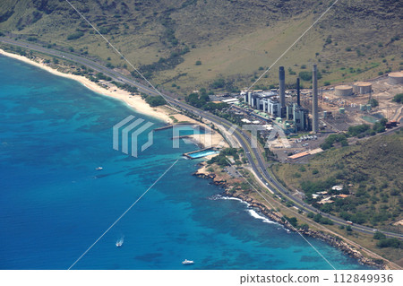 Aerial view of Kahe Point Power Plant along the ocean with highway road 112849936