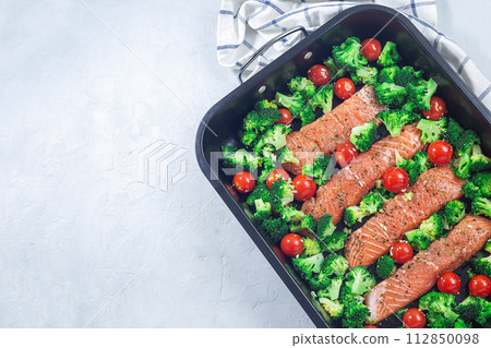 Ready to bake raw salmon fillet with broccoli and tomato, horizontal, top view, copy space 112850098