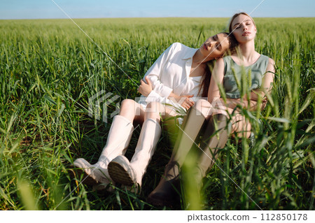 Two Beautiful woman in the green field. Nature, vacation, relax and lifestyle. Summer landscape. 112850178