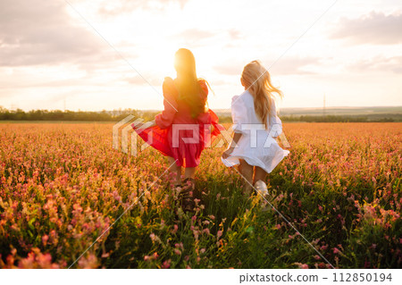 Two Beautiful woman in a field. Nature, fashion, vacation and lifestyle. 112850194
