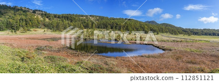 A panoramic view of Kagamiike Pond in autumn, shrouded in silence against the blue sky. 112851121