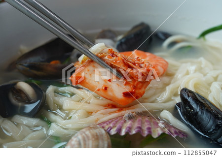Kalguksu with seafood is made by boiling thin noodles with seafood, such as shrimp, octopus, and clam, in a baby clam broth. 112855047