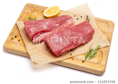 Fresh tuna Fish steak on a wooden cutting serving board isolated on a white background Fresh tuna Fish steak on a wooden cutting serving board isolated on a white background 112855356