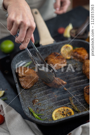 marinated pieces of Organic Tuna Steak frying on a hot grill pan marinated pieces of Organic Tuna Steak frying on a hot grill pan 112855363