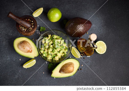 Chopped avocado in glass bowl and avocado Halves Chopped avocado in glass bowl and avocado Halves 112855384