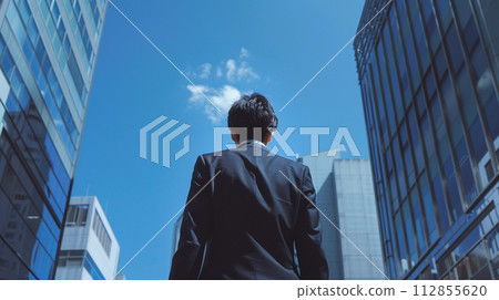 Businessman looking up at the building street 112855620