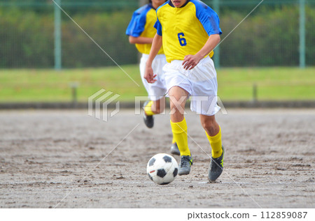 Youth soccer match (player dribbling) Youth soccer match (player dribbling) 112859087