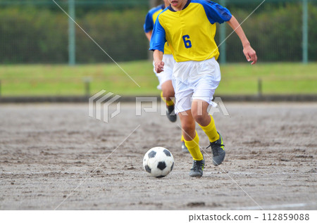 Youth soccer match (player dribbling) Youth soccer match (player dribbling) 112859088