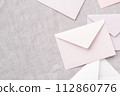 灰布背景和淡粉紅色和白色信封的俯視圖 112860776