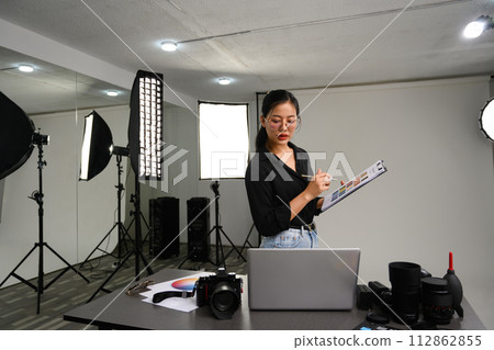 Attractive stylish woman using laptop in her modern photo studio. Creative career Concept Attractive stylish woman using laptop in her modern photo studio. Creative career Concept 112862855