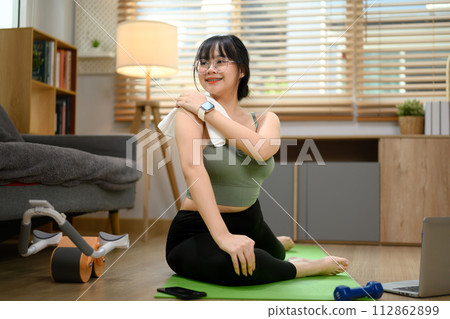 Pretty young woman practicing yoga in living room. Healthy lifestyle concept 112862899