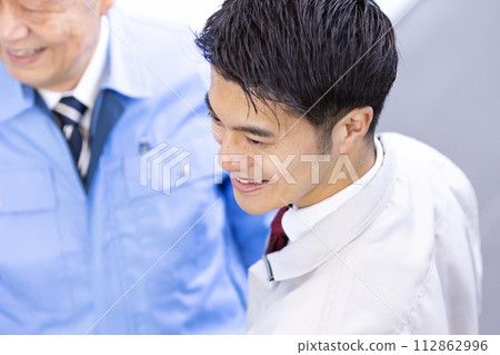 2 men in work clothes fist pump 112862996