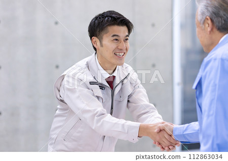 Man in work clothes Shaking hands 112863034