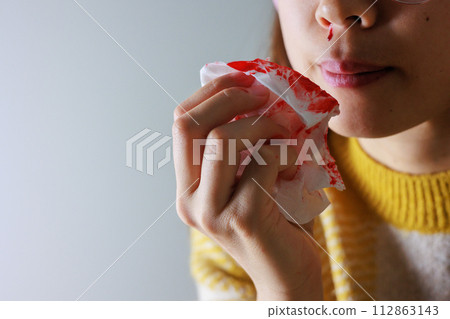 Woman wiping nosebleed with tissue Woman wiping nosebleed with tissue 112863143