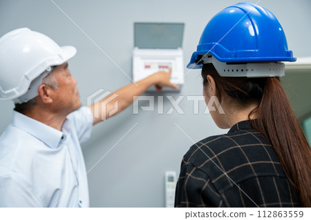 Senior home inspector checking home defects and teaching young engineers, before handing it over to client. Young engineers learn home inspection with Senior, Real estate, and renovation concepts. Senior home inspector checking home defects and teaching young engineers, before handing it over to client. Young engineers learn home inspection with Senior, Real estate, and renovation concepts. 112863559