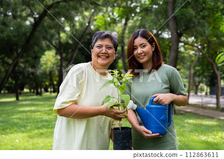 Portrait, Asian family mom and daughter plant sapling tree outdoors in nature park, Concept of happy retirement With care from a caregiver and Savings and senior health insurance, Happy family 112863611