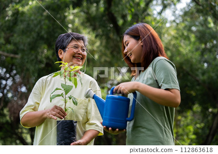 Portrait, Asian family mom and daughter plant sapling tree outdoors in nature park, Concept of happy retirement With care from a caregiver and Savings and senior health insurance, Happy family 112863618