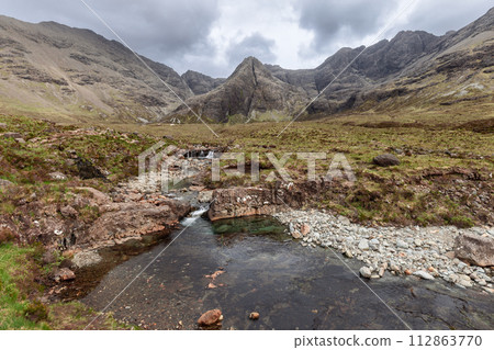 Tranquil beauty of the Fairy Pools, with crystal-clear waters and majestic Cuillin backdrop Tranquil beauty of the Fairy Pools, with crystal-clear waters and majestic Cuillin backdrop 112863770