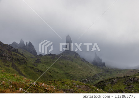 Distinctive pinnacle, the Old Man of Storr, pierces the fog on the Isle of Skye rugged landscape Distinctive pinnacle, the Old Man of Storr, pierces the fog on the Isle of Skye rugged landscape 112863773