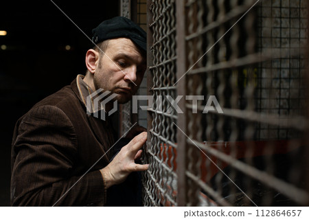 A middle-aged homeless man looks for treasures in the dustbin. A middle-aged homeless man looks for treasures in the dustbin. 112864657