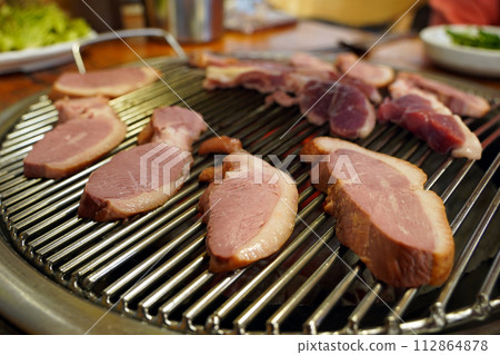 Duck meat is being grilled on the grill. Duck meat is being grilled on the grill. 112864878