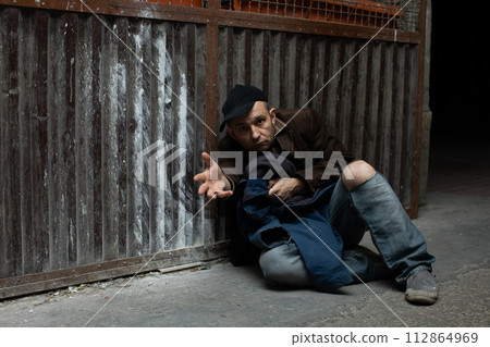 A middle-aged homeless man asks for help. 112864969