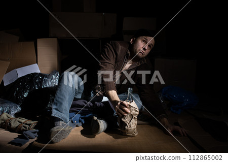 A middle-aged homeless man puts on woolen gloves. A middle-aged homeless man puts on woolen gloves. 112865002
