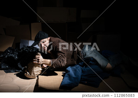 A middle-aged homeless man became alcoholic because of his situation. 112865083