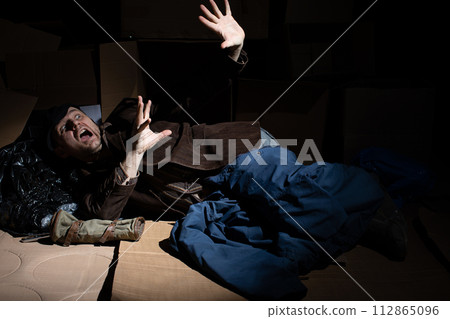A middle-aged homeless man defends himself against danger. 112865096