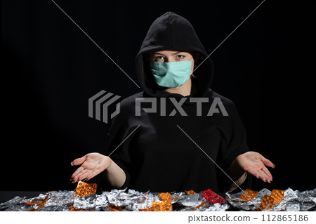 A teenager in a protective mask found many packages of various medications. A teenager in a protective mask found many packages of various medications. 112865186