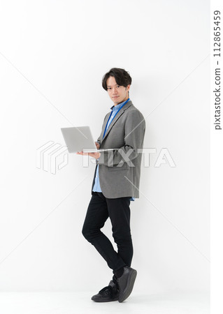 Businessman standing with laptop 112865459