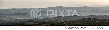 Typical Tuscan landscape with hills and cypresses in the very early morning near Montaione Typical Tuscan landscape with hills and cypresses in the very early morning near Montaione 112865960