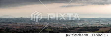 Typical Tuscan landscape with hills and cypresses in the very early morning near Montaione 112865997