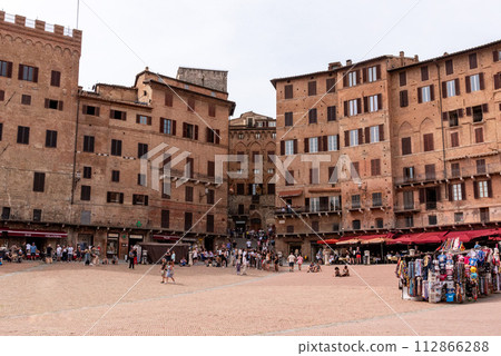 Old medieval brick houses surrounding the famous Piazza del Campo in the center of Siena 112866288