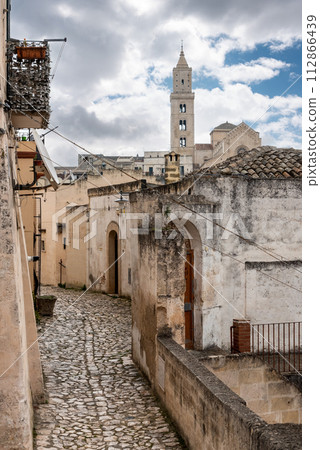 A narrow alley with cobblestones somewhere in the historic city of Matera, Italy 112866439