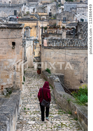 A person walking through the rain on a path in downton Matera, Italy A person walking through the rain on a path in downton Matera, Italy 112866449